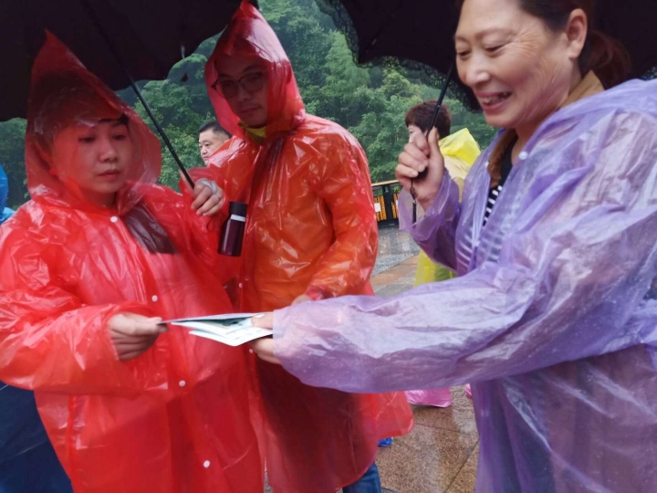 志愿者冒雨为游客发送禁毒宣传资料.jpg