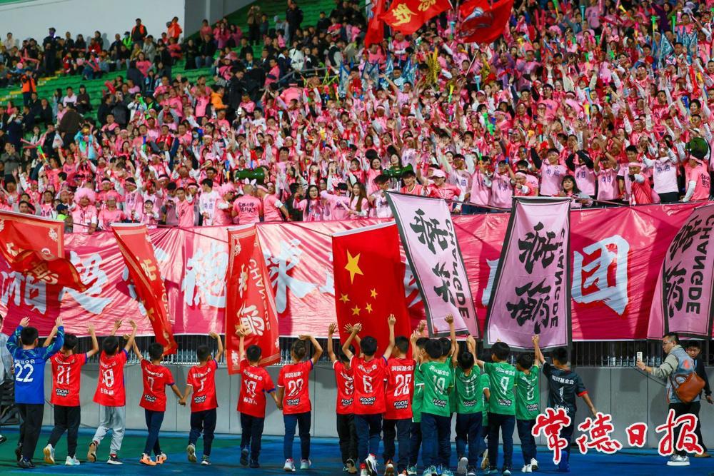 石门县第五完全小学的足球小将们向“湘超”常德球迷助威团致敬